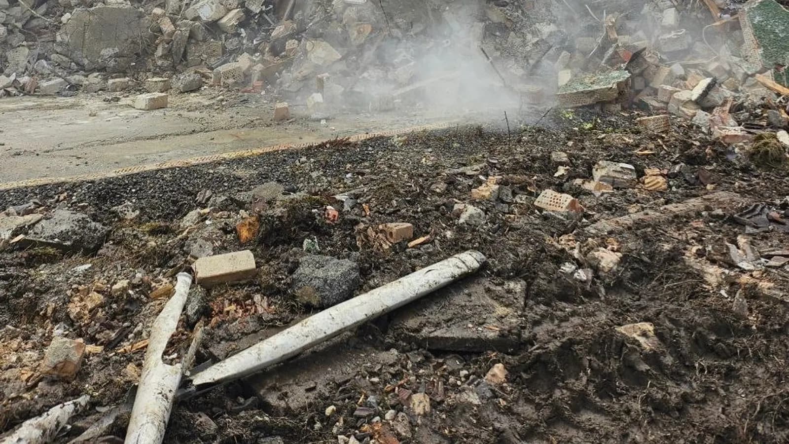 Sortierter Bauschutt auf einer Abrissbaustelle: getrennte Haufwerke aus Beton, Ziegel und Metall