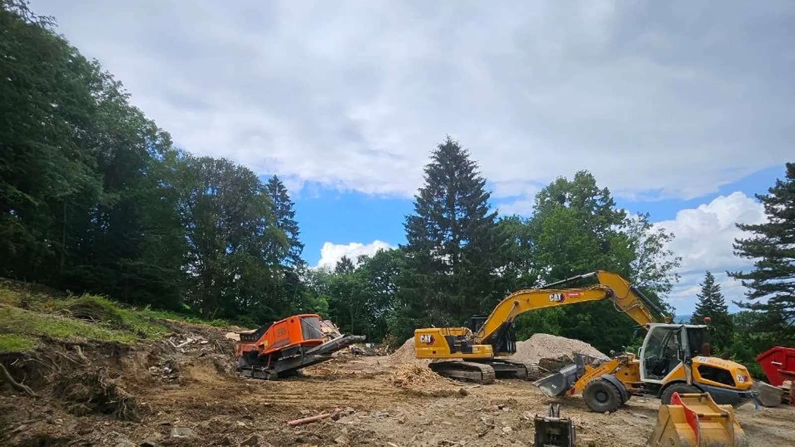 Baustellenräumung: geräumtes Abrissgrundstück mit Radlader, Bagger und mobiler Brechanlage