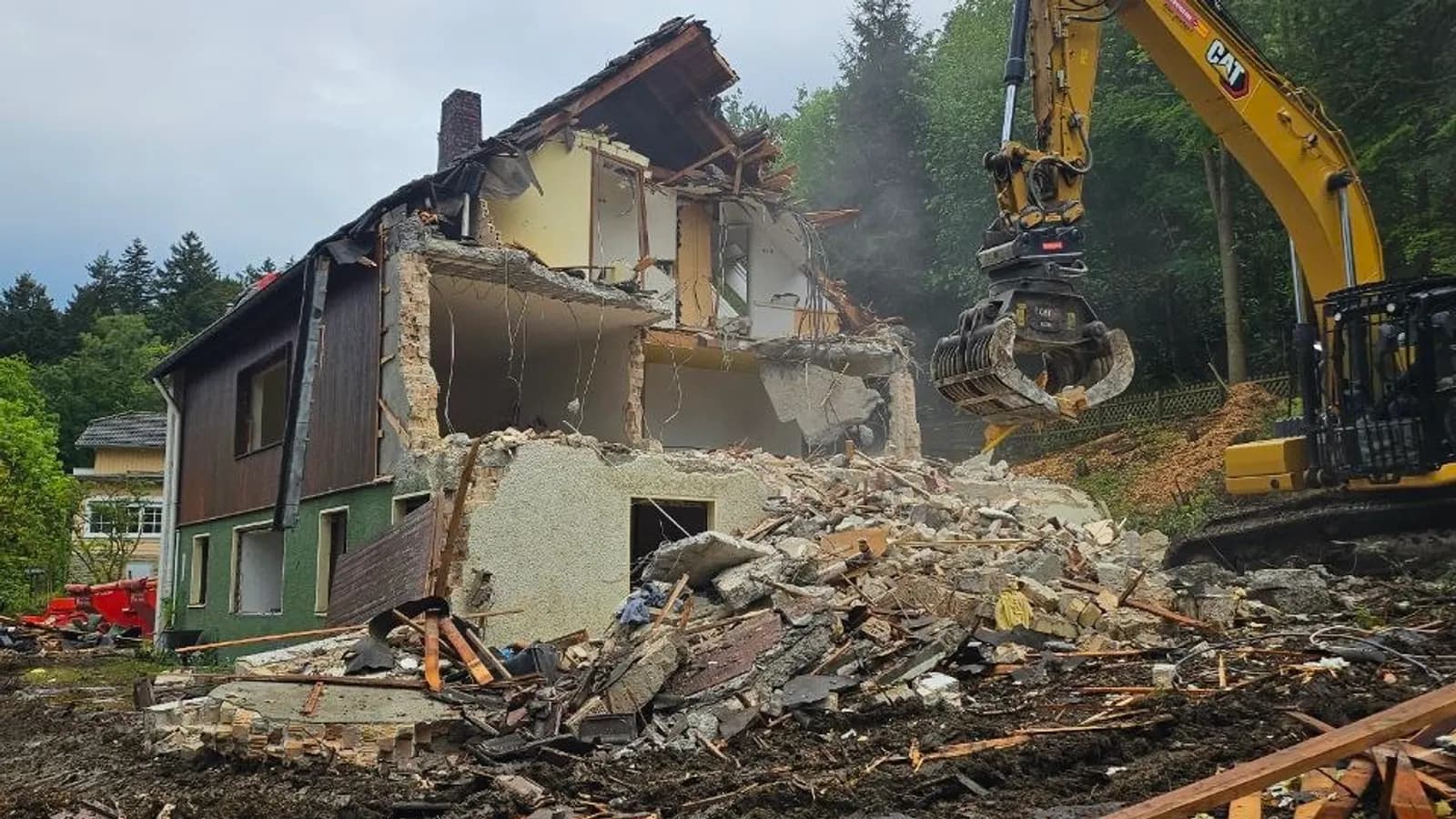 Hausabriss Goslar: Bagger mit Sortiergreifer vor einem teilweise abgetragenen Wohngebäude